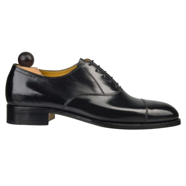 Side view-1 of men’s black calf leather cap toe Oxford shoe on F last with a single sole – handmade by Vass Shoes.