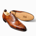 Side view of men’s light gold museum calf leather cap toe Oxford shoe on F last with a single sole – handmade by Vass Shoes.