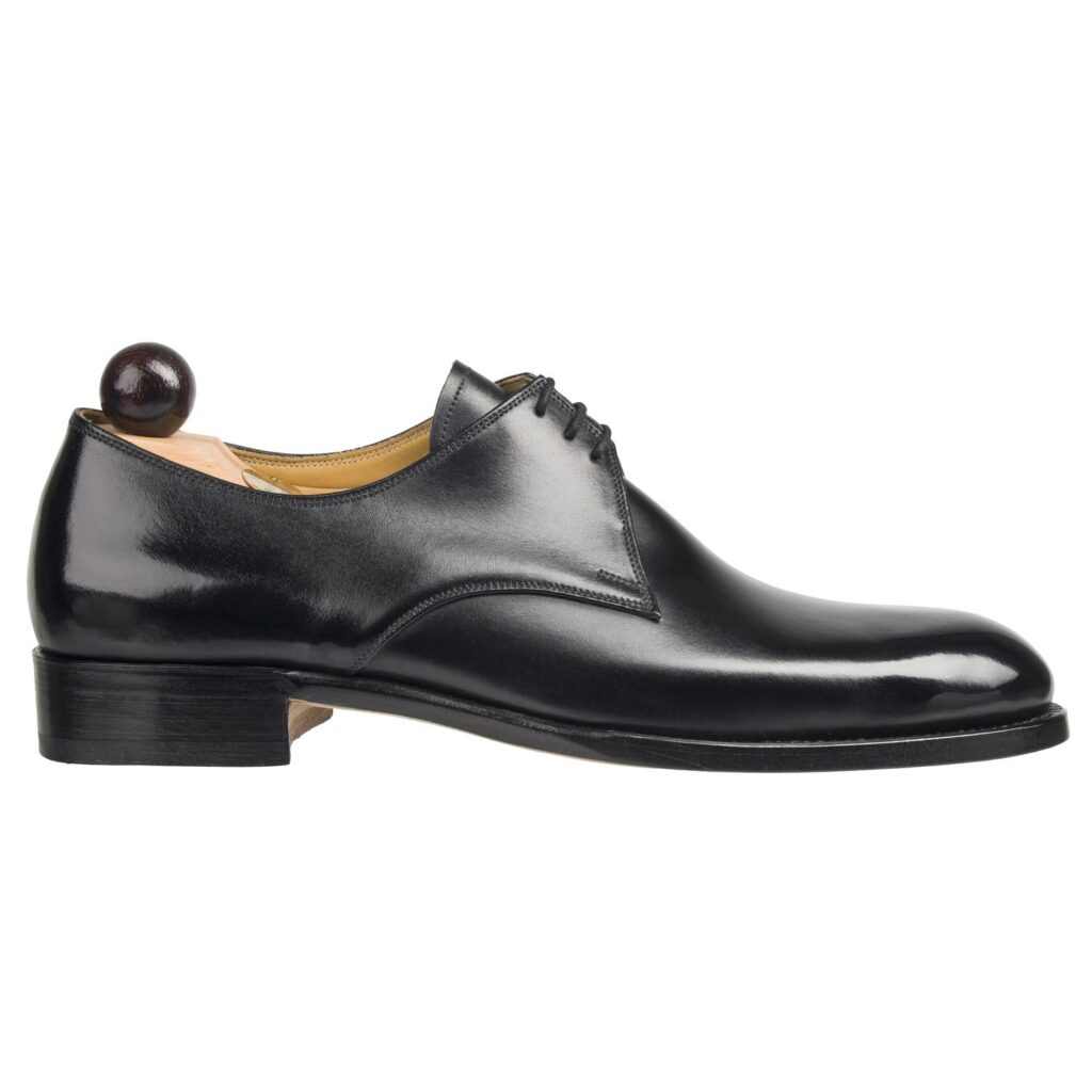 Angle view of men’s black London 3-eyelet Derbyshoe on F last with a single sole – handmade by Vass Shoes.