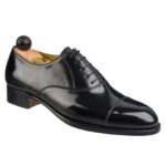 Angle view of men’s black calf leather cap toe Oxford shoe on F last with a single sole – handmade by Vass Shoes.