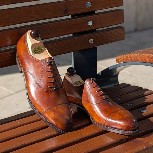 Angle view-2 of men’s light gold museum calf leather cap toe Oxford shoe on F last with a single sole – handmade by Vass Shoes.