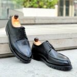 Angle view of men’s black scotchgrain Norweger shoe on P last with a vibram sole – handmade by Vass Shoes.