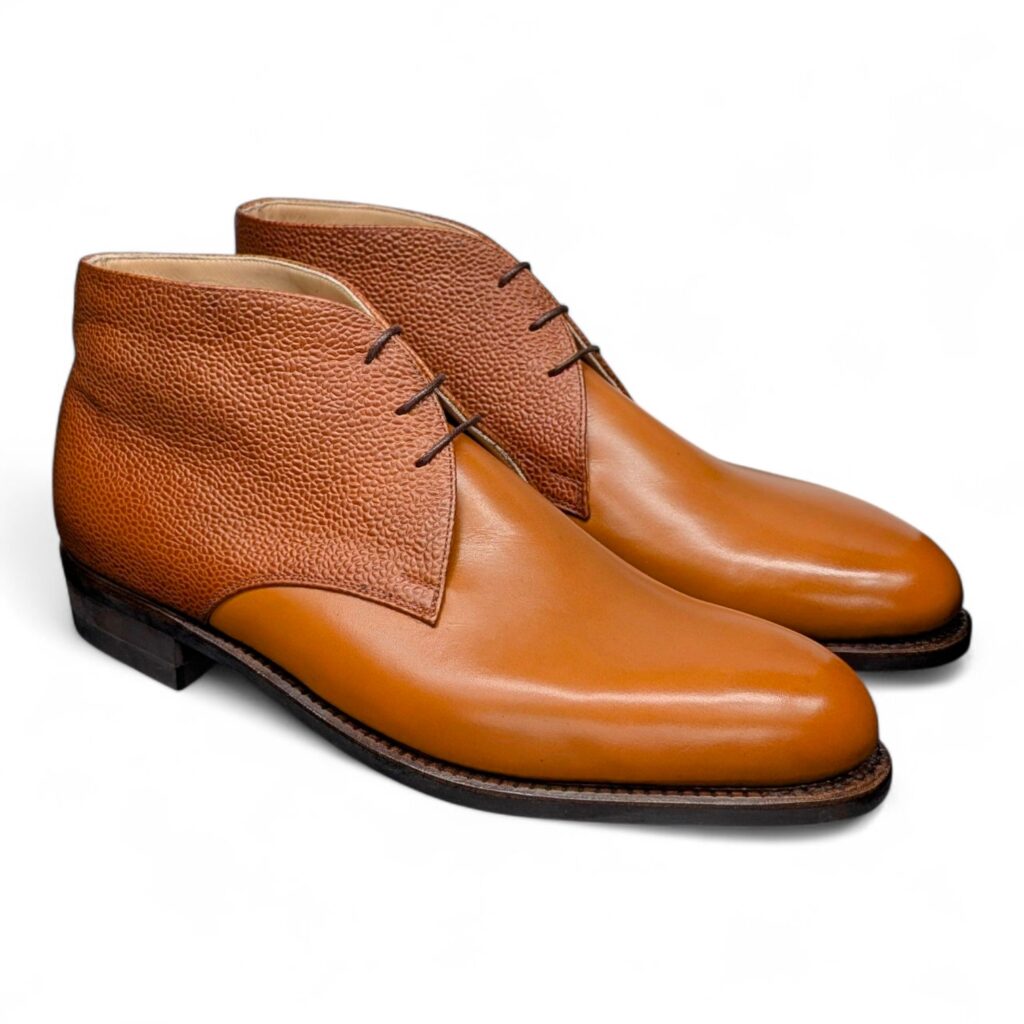 Angle view-1 of men’s cognac 3-eyelet Chukka boots on P2 last with a dainite sole – handmade by Vass Shoes.